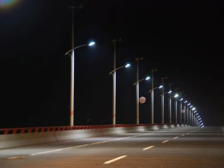 Roadway lighting columns receding along an elevated highway at night